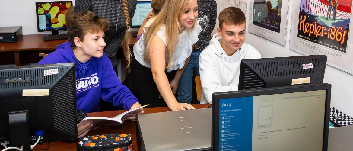 Uczniowie przy komputerach na lekcji informatyki